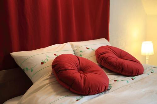 two red pillows sitting on top of a bed at B&B Adem in Horebeke