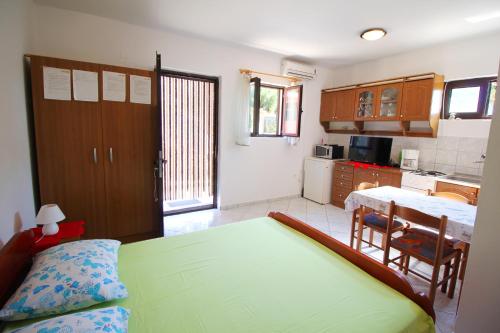 Cet appartement comprend une chambre avec un lit et une cuisine avec une table. dans l'établissement Dubravka, à Dinjiška
