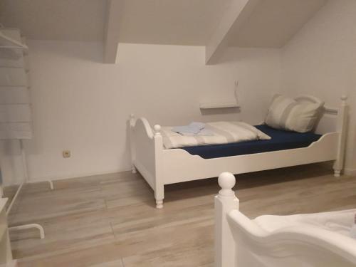 a bedroom with a white bed and a wooden floor at Ferienhaus am Burggraben in Stendal