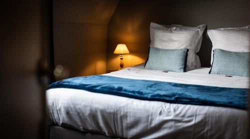 a bedroom with a large bed with blue sheets and pillows at B&B Maison Rabelais in De Haan