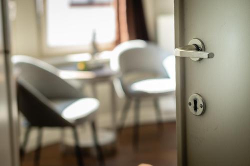 a door with chairs and a table in a room at B&B Maison Rabelais in De Haan