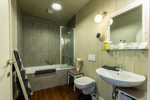 a bathroom with a sink and a toilet and a tub at B&B Maison Rabelais in De Haan
