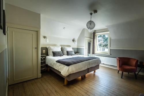 - une chambre avec un lit, une chaise et une fenêtre dans l'établissement B&B Maison Rabelais, au Coq