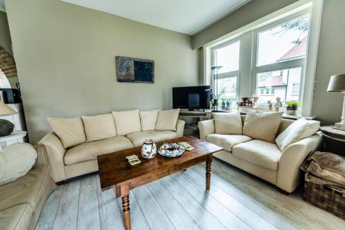 a living room with two couches and a coffee table at B&B Maison Rabelais in De Haan