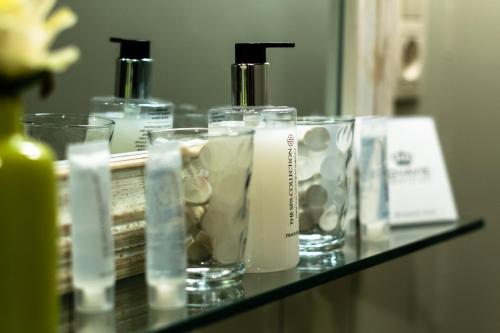 a shelf with three bottles of moisturizers on it at B&B Maison Rabelais in De Haan