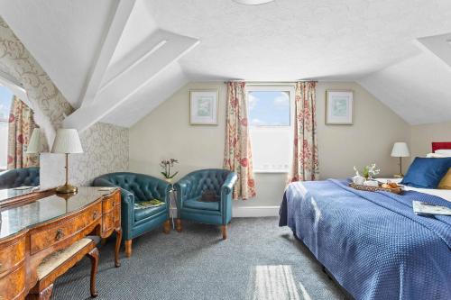 a bedroom with a bed and two chairs at The Westgate in Torquay