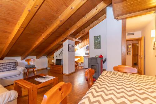 a room with a bed and a living room with a table at Dimora Catitti in Mazzin