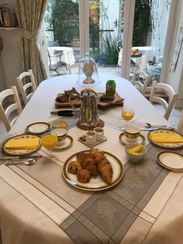 a table with food and orange juice and croissants on it at Le 31 B&B Amboise Centre in Amboise