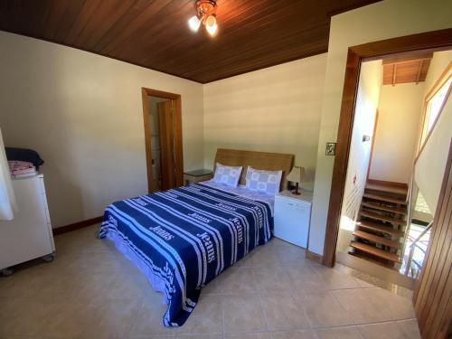 a bedroom with a bed with a blue blanket at Linda Casa Buzios in Búzios