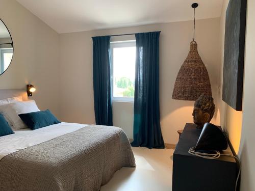 a bedroom with a bed and a window at La Blanchisserie in Maussane-les-Alpilles