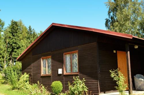 a small wooden house with a red roof at CAMP VARY - Vítkova Hora in Karlovy Vary