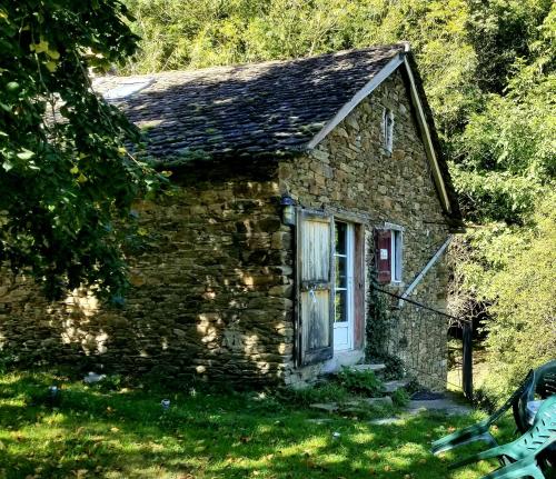 an old stone house with a door in the grass at Soulié du Tarn avec magnifique vue sur la rivière et la vallée in Réquista