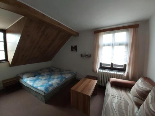 フジェンスコにあるHotel Hubertのベッドルーム1室(ベッド1台、ソファ、テーブル付)