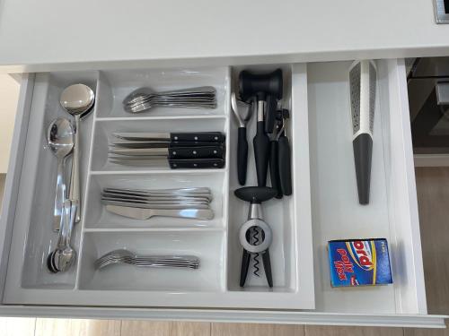 a white drawer filled with silver utensils at Citadela in Primošten
