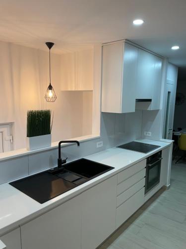 a kitchen with white cabinets and a sink at Citadela in Primošten