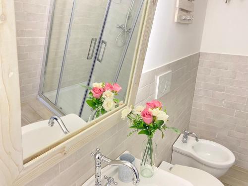 ein Badezimmer mit einem Waschbecken, einem WC und einem Spiegel in der Unterkunft Alla Luce del Barocco in Lecce