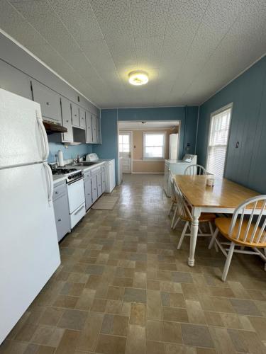 a kitchen with a table and a white refrigerator at Next to Seaside Boardwalk! - Spacious 3 Bedroom in Seaside Heights