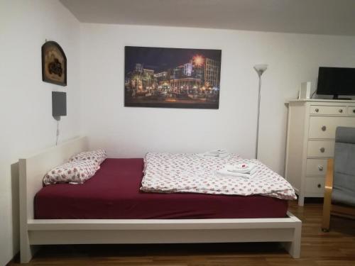 um quarto com uma cama e um quadro na parede em Ferienappartement Ruhrtal Witten em Witten