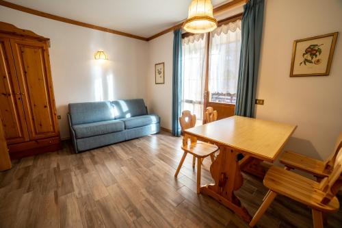 a living room with a blue couch and a table at Residence Derby Club in Folgaria