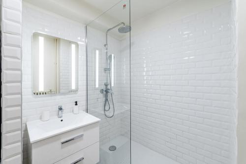 une salle de bain blanche avec un lavabo et une douche dans l'établissement Gare St Charles- Superbe appartement avec 3 chambres, à Marseille