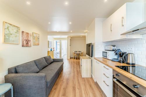 une cuisine et un salon avec un canapé dans une pièce dans l'établissement Gare St Charles- Superbe appartement avec 3 chambres, à Marseille