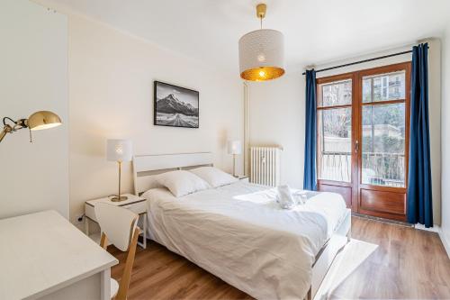 une chambre avec un grand lit blanc et une fenêtre dans l'établissement Gare St Charles- Superbe appartement avec 3 chambres, à Marseille