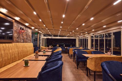 イスタンブールにあるTarabya Suitesの木製テーブルと青い椅子が備わるレストラン