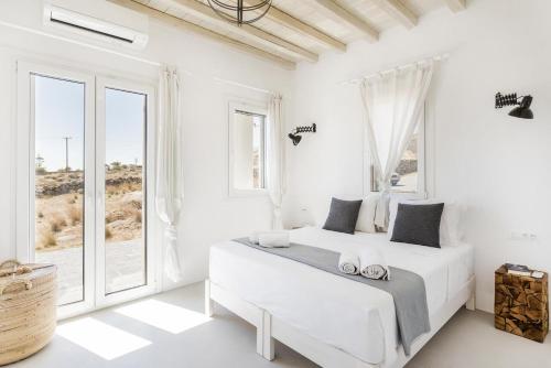Duas camas num quarto branco com janelas em Ocean view villa em Míconos
