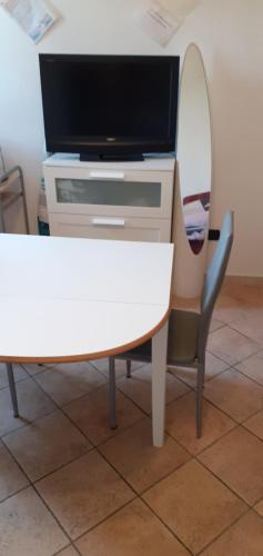 a desk with a tv and a table and a chair at Via Pioppa 24 in Ferrara