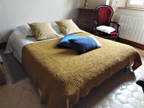 un letto con due cuscini blu sopra di Les Cimaises du Couvent a Beaune