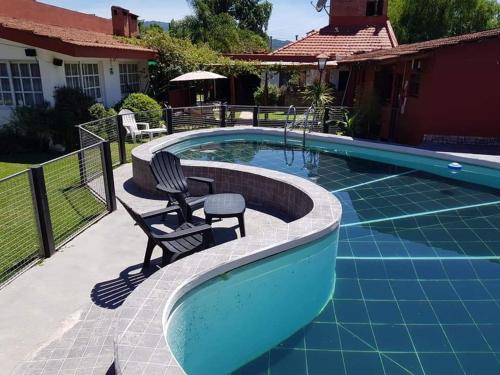 einen Pool mit zwei Stühlen neben einem Haus in der Unterkunft La Casa de Reyes Posada in Reyes