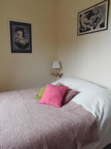 - un lit avec 2 oreillers roses dans l'établissement Les Cimaises du Couvent, à Beaune