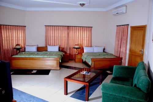 a living room with two beds and a couch at Eastgate Hotel in Accra