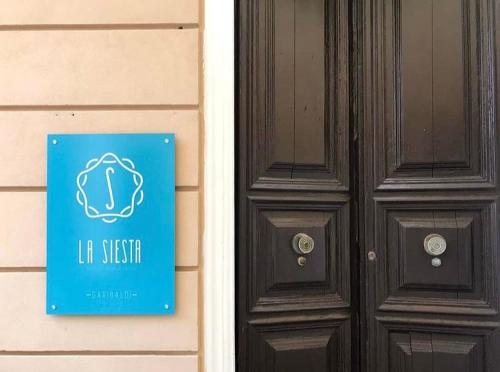 a door with a sign next to a house at La Siesta in La Maddalena