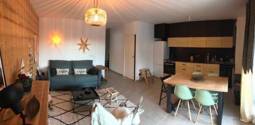 a kitchen and living room with a table and a couch at La Tintaine- T2 avec Terrasse in Villard-de-Lans