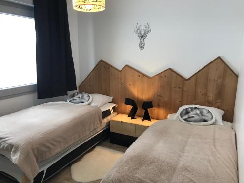 a bedroom with two beds and a window at La Tintaine- T2 avec Terrasse in Villard-de-Lans
