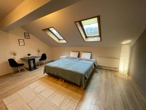 a bedroom with a bed and a table and windows at Skalny Dworek in Brenna