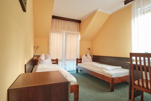 a room with two beds and a desk and a window at Willa Preludium in Gdańsk