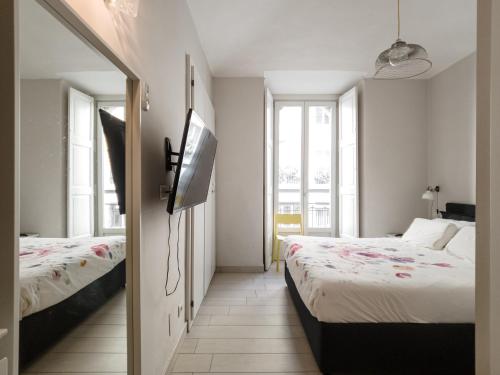 a bedroom with two beds and a flat screen tv at Torino Centro Corso Matteotti in Turin
