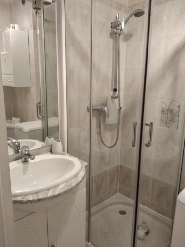 une salle de bain avec douche et lavabo dans l'établissement Résidence Le Vallon à 180 m de la plage, à Saint-Georges-de-Didonne