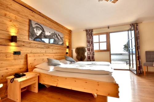 a bedroom with two beds in a wooden wall at Seehotel Hartung & Ferienappartements in Füssen