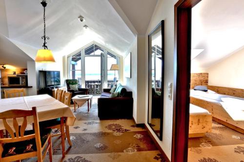 a room with a dining table and a living room at Seehotel Hartung & Ferienappartements in Füssen