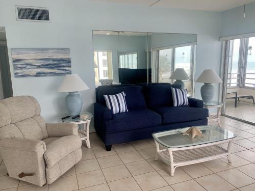 a living room with a blue couch and a chair at Island House Beach Resort 5S in Siesta Key