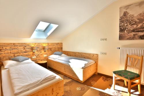 two beds in a room with a skylight at Seehotel Hartung & Ferienappartements in Füssen
