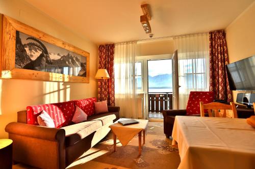 ein Wohnzimmer mit einem Sofa und einem TV in der Unterkunft Seehotel Hartung & Ferienappartements in Füssen