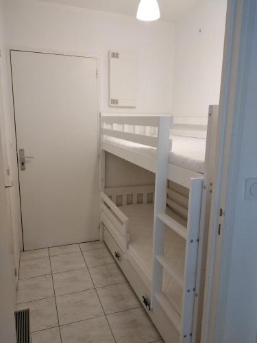 Cette chambre comprend 2 lits superposés et une porte. dans l'établissement Résidence Le Vallon à 180 m de la plage, à Saint-Georges-de-Didonne