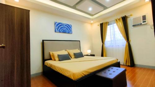 ein Schlafzimmer mit einem Bett mit gelber Bettwäsche und einem Fenster in der Unterkunft KASSFFER APARTMENT in Panglao
