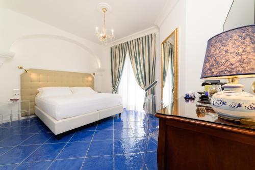 ein Schlafzimmer mit einem Bett und einem Tisch mit einer Lampe in der Unterkunft La Casa di Paolo Casa di Charme in Marina di Camerota