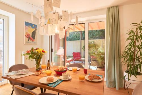 una sala da pranzo con tavolo in legno e cibo di Rotes Haus Bregenz Pop-Up Wohnung a Bregenz