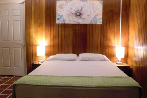 a bedroom with a bed with two lamps on both sides at Casa Central completa in Santa Ana